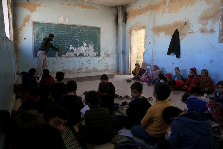 Suriye'nin İdlib ilinde öğrenciler soğuk sınıflarda yere oturarak eğitim görüyor